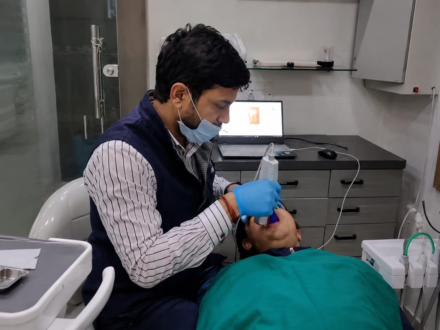 Dr. Sandeep Kumar using a digital intraoral scanner on a patient at The DentalBrace Clinic Bathinda — advanced iTero digital dental impression technology